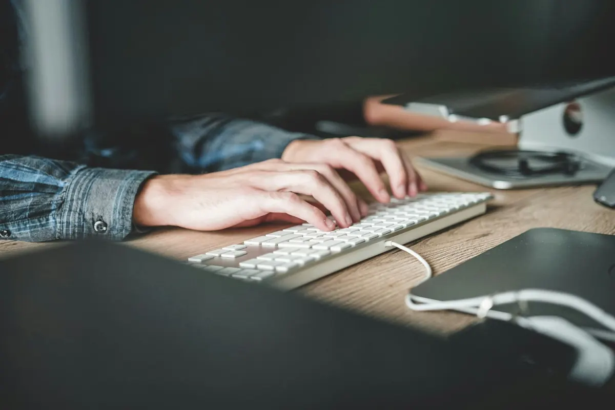 Hände, die auf einer Tastatur einen Text schreiben — der Moment, in dem eine Bandgeschichte entsteht statt nur Fakten aufgelistet werden